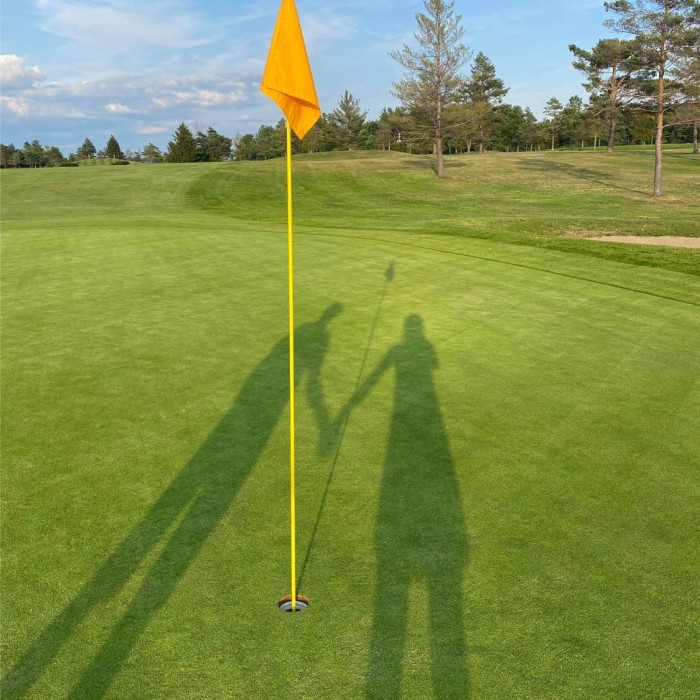 Ombres d'Amélie Champagne et son père se tenant la main sur un terrain de golf